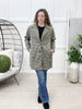 Women's black and cream houndstooth long coat with button front, relaxed fit, and pockets, styled with jeans.
